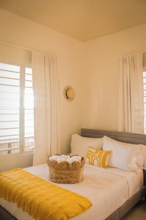 A bedroom with a bed, a basket, and curtains. - Entire beachfront villa in Salinas, Puerto Rico (Salinas)