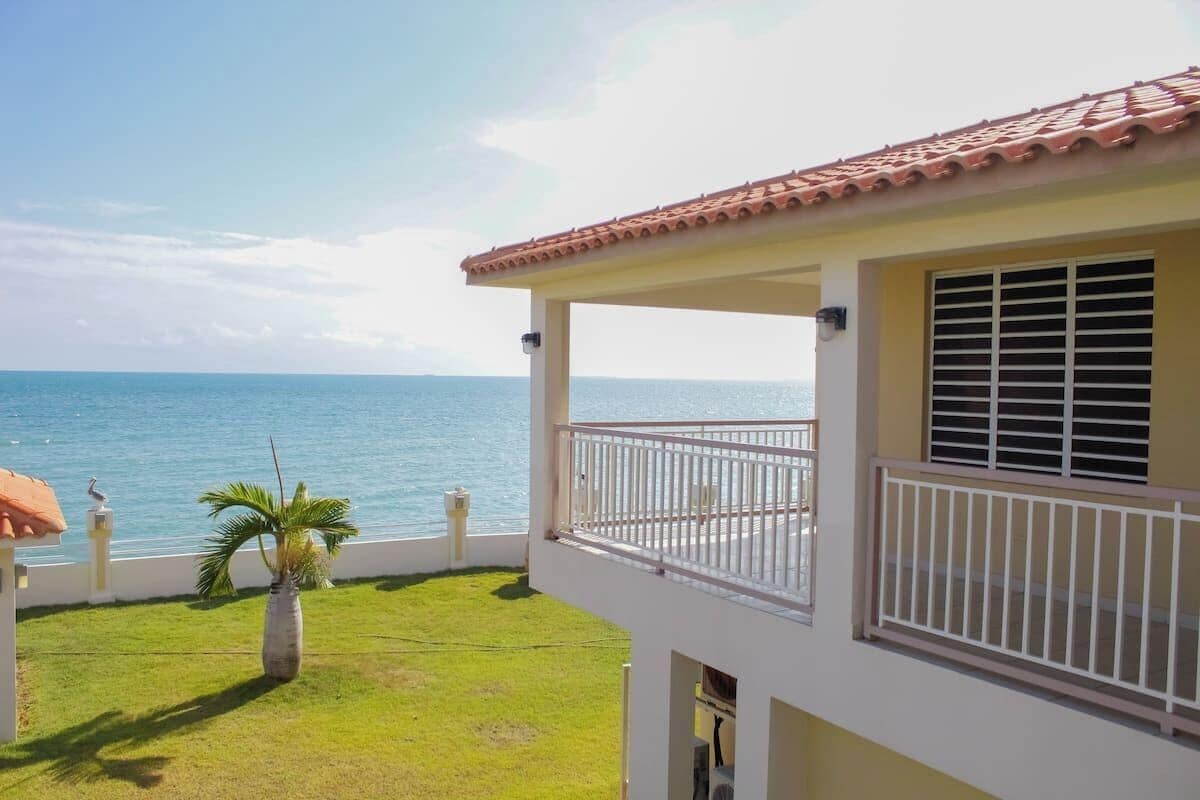 A building with a balcony overlooking a body of water.