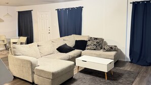 A living room with a sectional sofa, a coffee table, and a rug. -  A Peaceful Richmond Stay in Houston Made for Comfort & Memories. (Richmond)