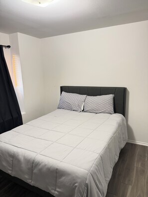 A bedroom with a bed, a headboard, and a window with curtains. -  A Peaceful Richmond Stay in Houston Made for Comfort & Memories. (Richmond)