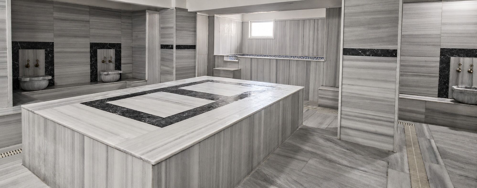 Un baño moderno con una isla central grande, ducha integrada y tocador con espejo.