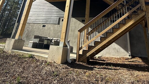 Una casa de dos pisos con un balcón y una escalera de madera que lleva a él.