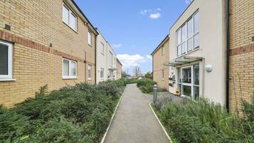 A pathway between two brick buildings with a clear sky.