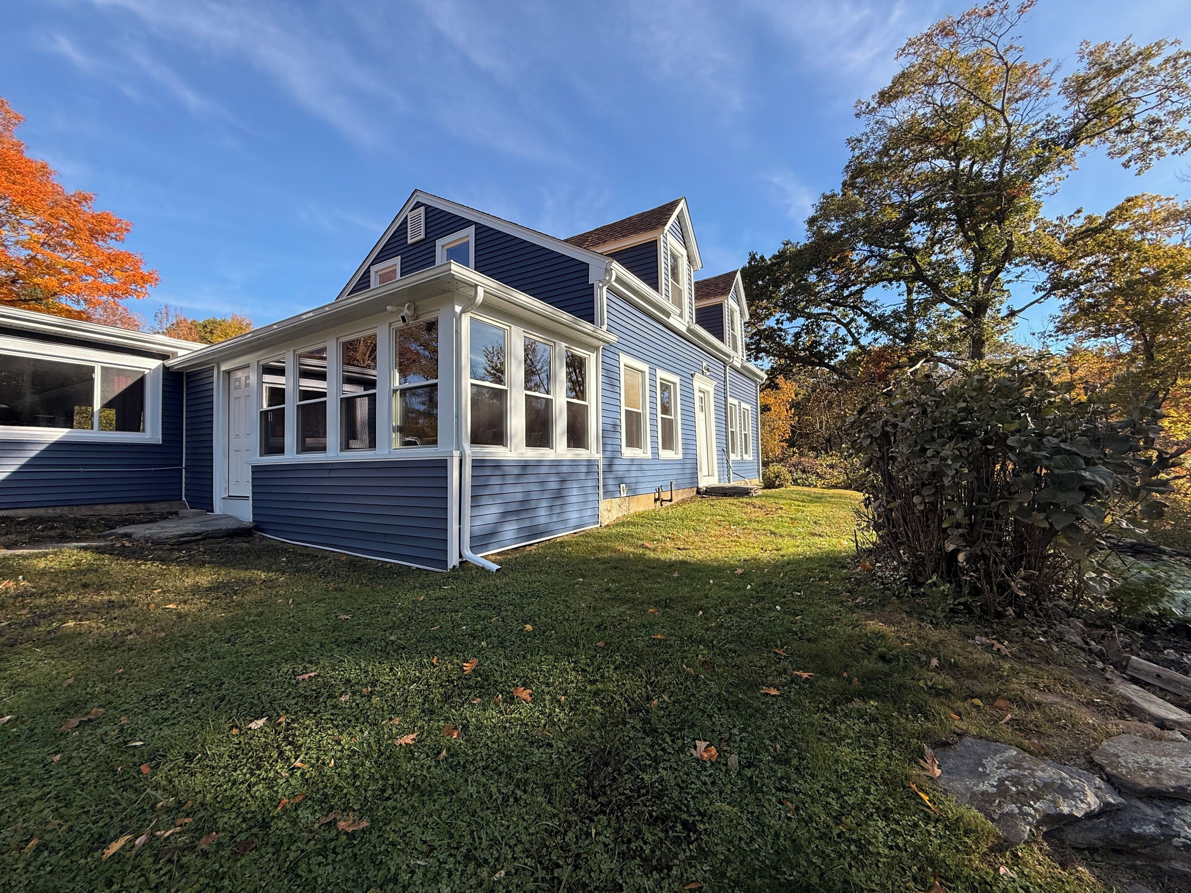 A two-story house with a covered porch and a well-maintained lawn.