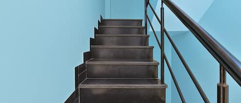 A staircase with a handrail and a light blue wall.