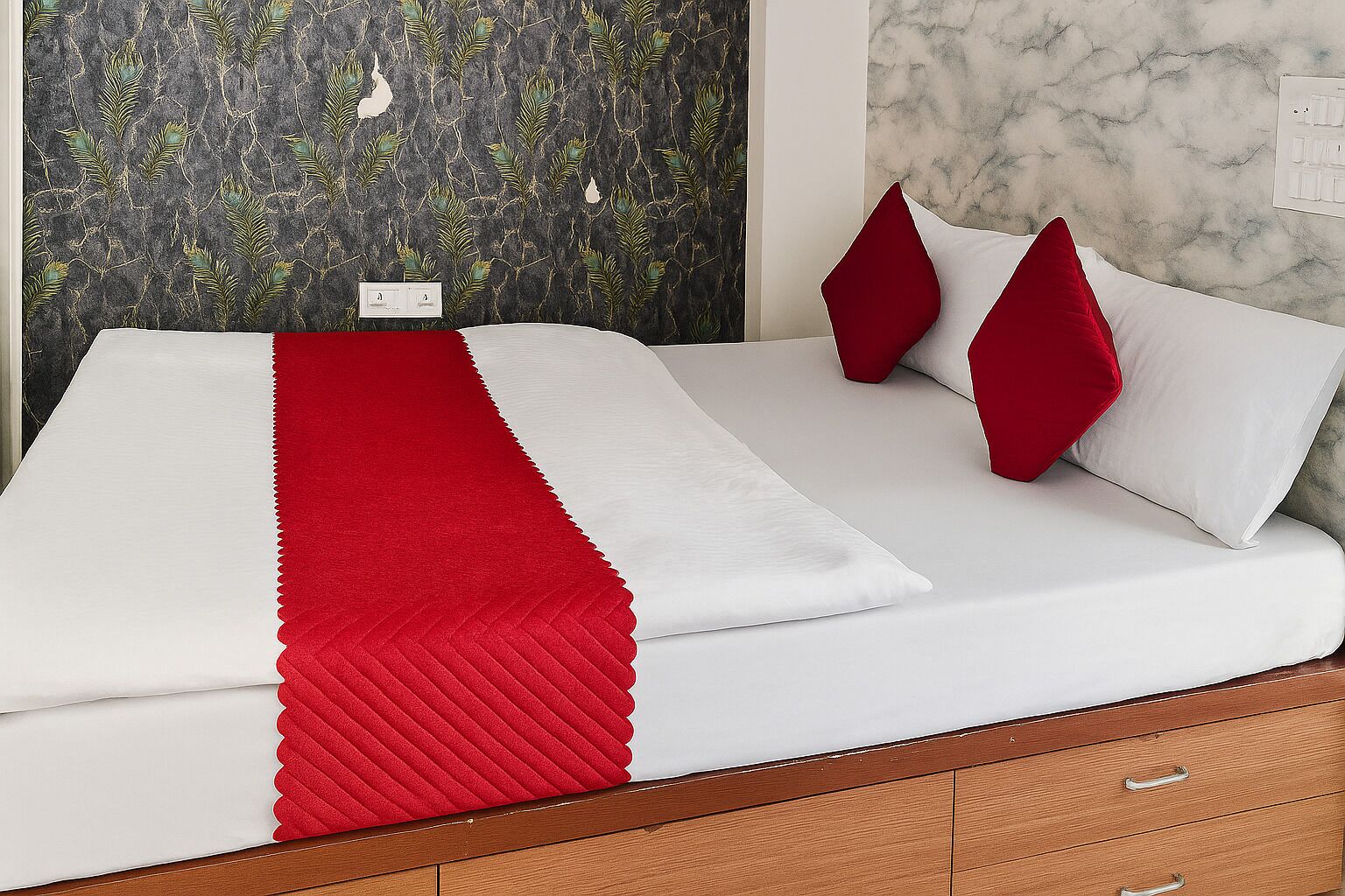 A bed with a white and red bedspread, two red pillows, and a wooden headboard.