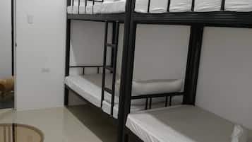 A bunk bed room with a round table and a small dog.