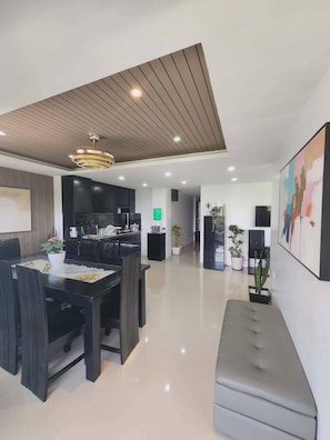 Uma sala de estar moderna com área de jantar, cozinha e espaço de estar com um banco.