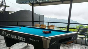 Una mesa de billar con piso a cuadros, con la marca 'Star Billiards' y 'MAXIMA 7+'.