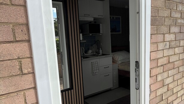 Ein modernes Interieur mit Küchenzeile, Essbereich und Schlafbereich.