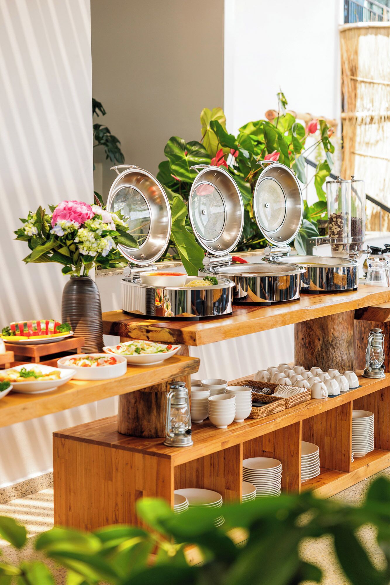A buffet setup with multiple serving dishes, a variety of food items, and a rustic wooden table.