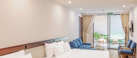 A hotel room with two beds, a balcony with seating, and a view of the outdoors.