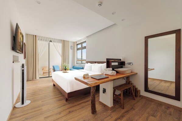 A hotel room with a bed, desk, and a large mirror.