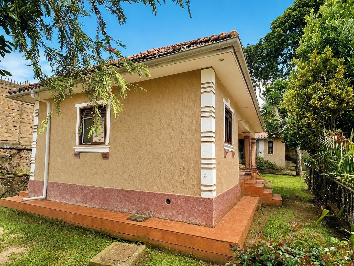 A single-story house with a flat roof, a small window, and a front porch.