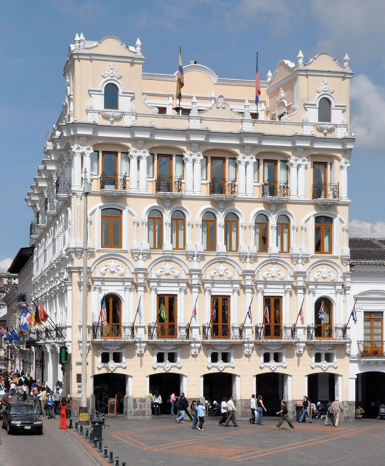 Un edificio histórico con varios balcones, ventanas amplias y banderas.