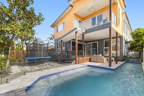 A two-story house with a swimming pool, outdoor seating, and a trampoline. - Poolside 2-bed House in Coolum Beach (Sunshine Coast)