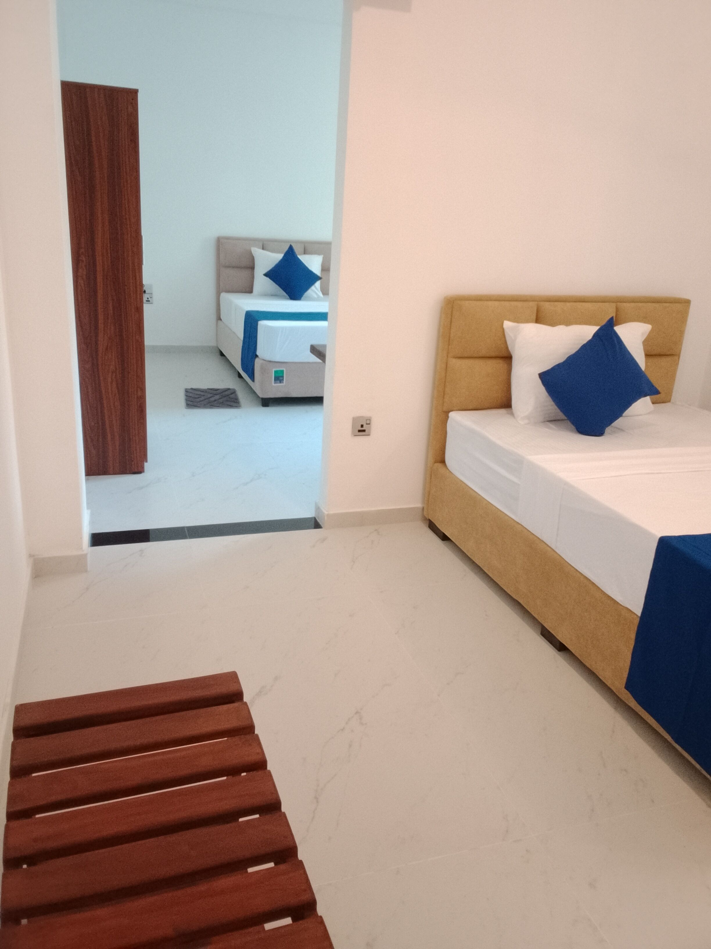 Un dormitori amb un llit, una panxa de fusta i vista a una altra habitació.