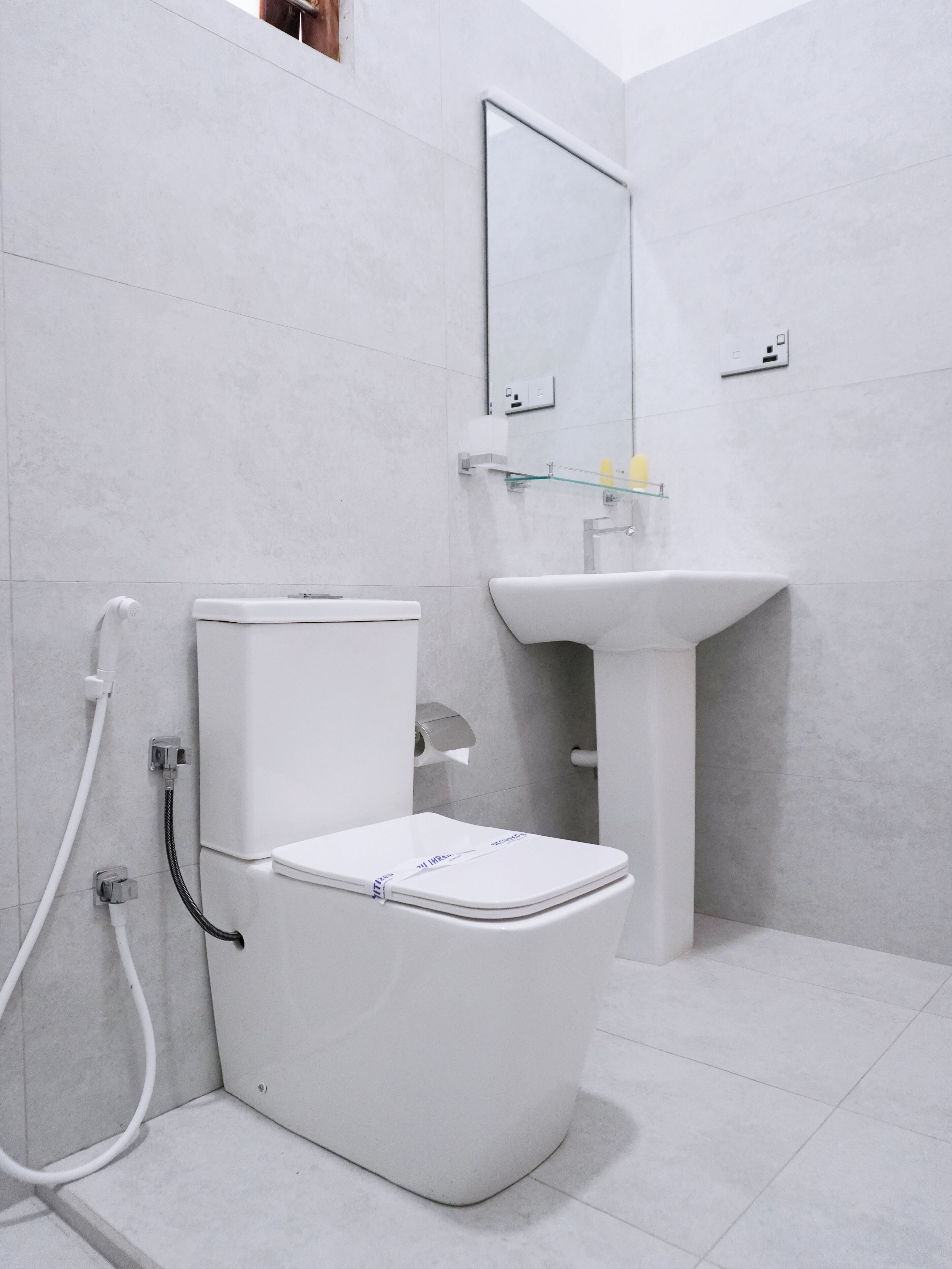 A modern bathroom with a toilet, sink, and shower.