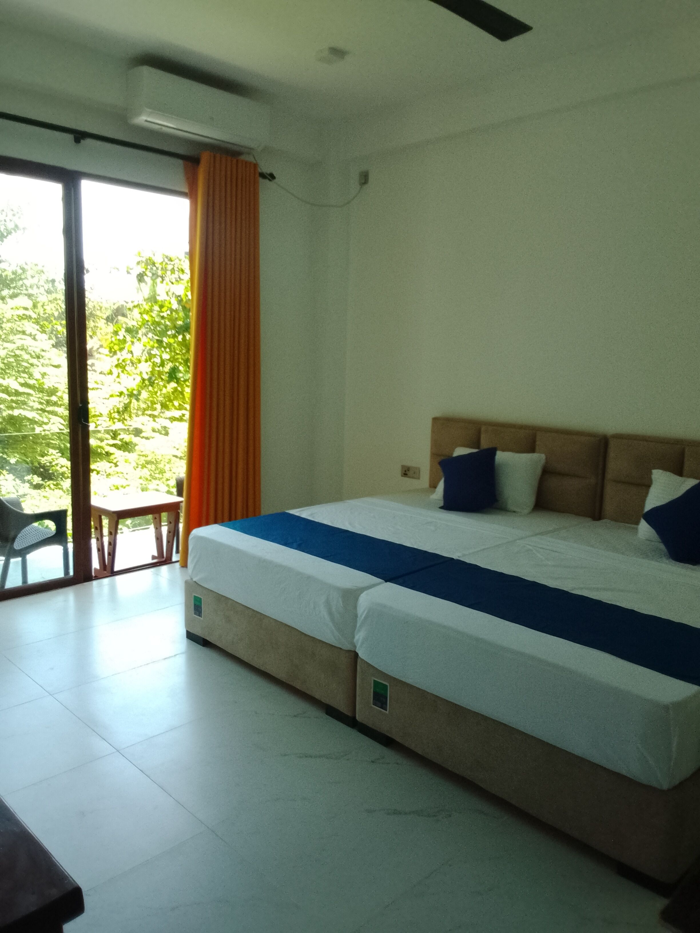 Una habitación de hotel con una cama, una mesa y vistas al verdor exterior.