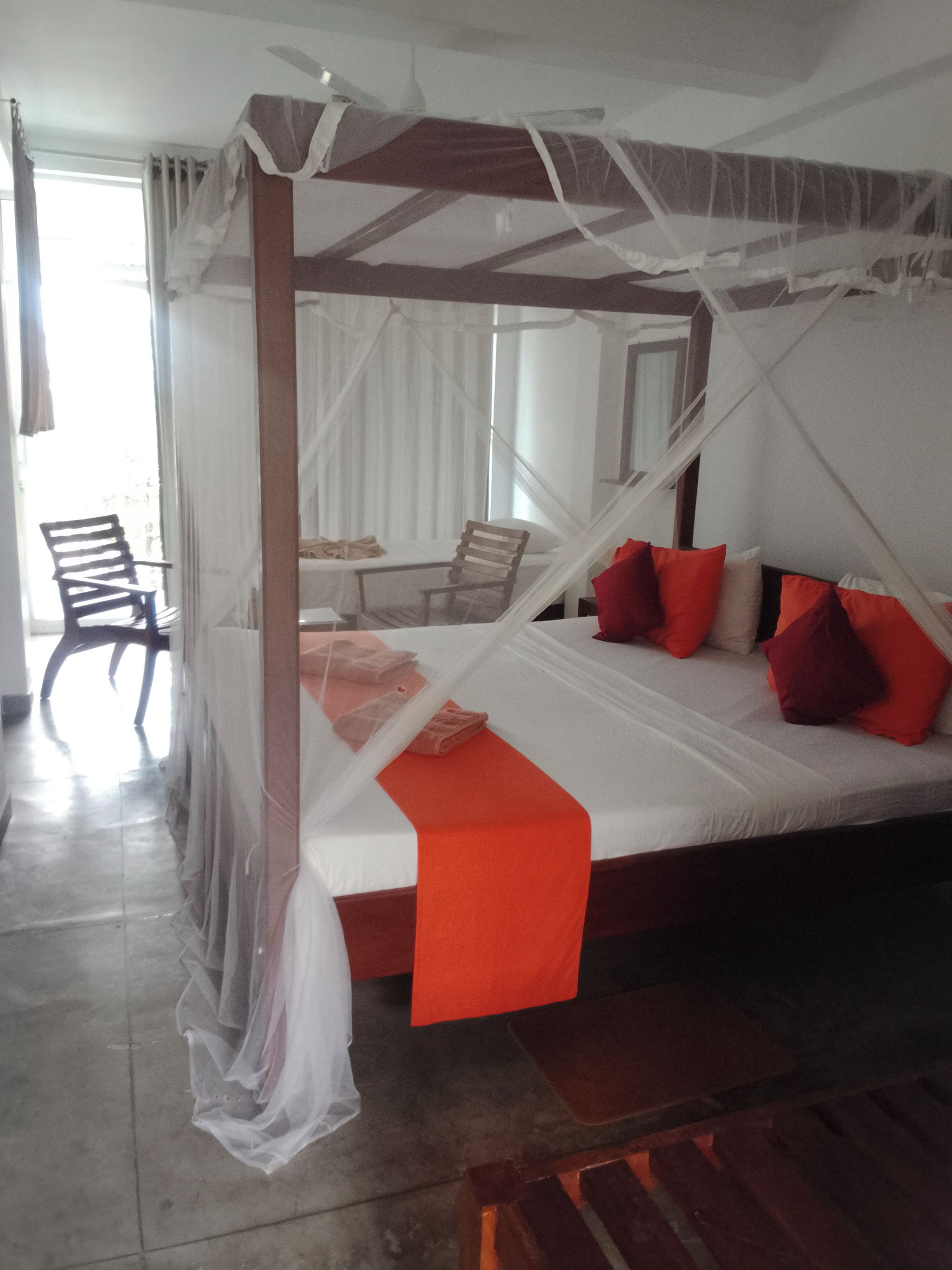 Een kamer met een bed, een stoel en een tafel.
