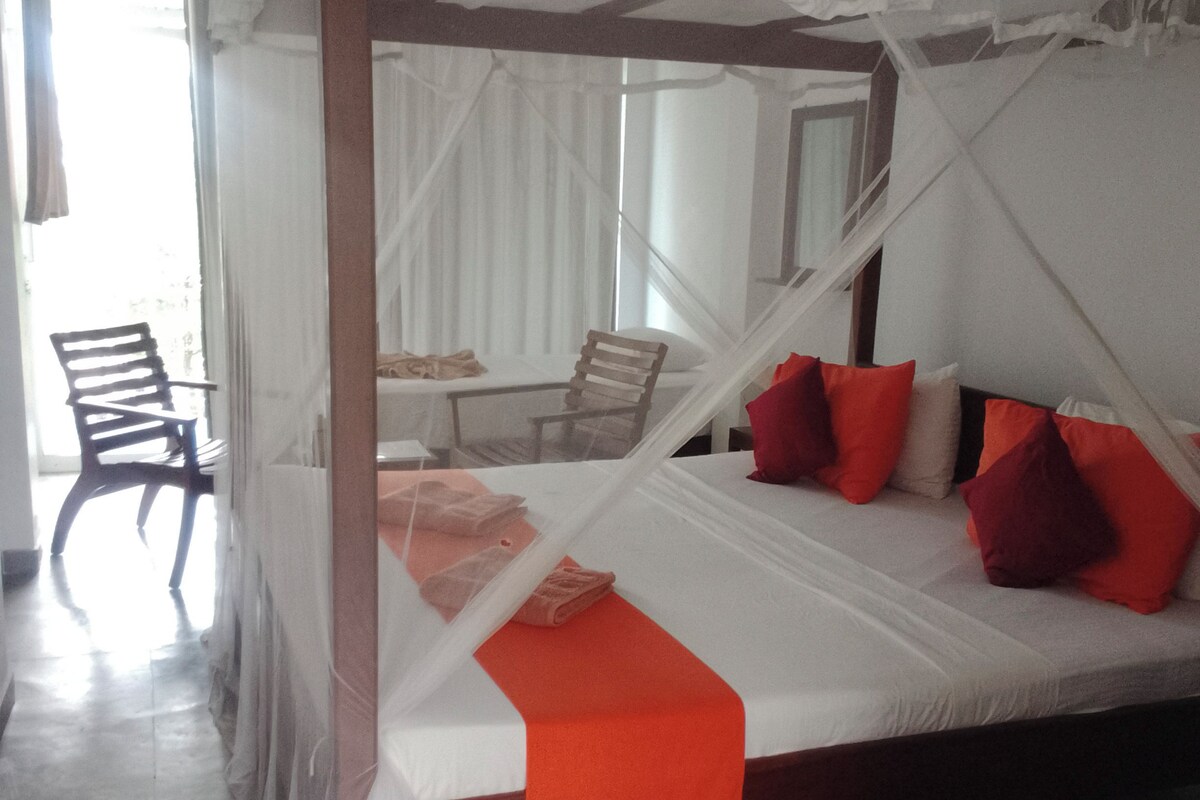A room with a bed, a chair, and a table.