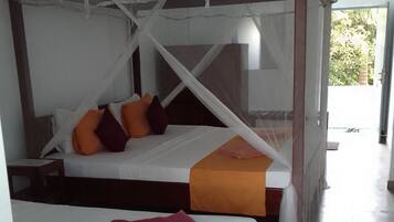 Una habitación con dos camas, cada una con dosel. Las camas tienen almohadas y una colcha.