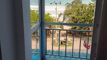 Un balcon avec vue sur la plage et une pancarte sur laquelle on peut lire « ÉCOLE ».