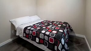 Un dormitorio con cama, ventilador de techo y colcha estampada.