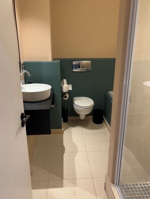A bathroom with a sink, toilet, and a small mirror. - Urban Escape | Mountain Views + Secure Parking (Cape Town)