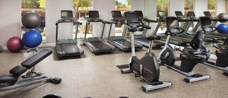 A gym with treadmills, elliptical machines, and free weights.