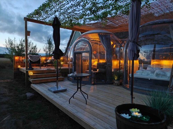 A cozy outdoor seating area with a wooden deck, a table, and chairs.