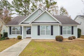 A two-story house with a front porch, a garage, and a well-maintained lawn.