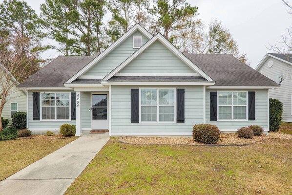 A two-story house with a front porch, a garage, and a well-maintained lawn.