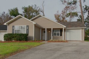 A single-story house with a front porch, a garage, and a well-maintained lawn. - Family-Friendly 4 Beds | Central & Fenced Yard (Valdosta)