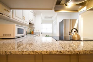 A kitchen with a granite countertop, stainless steel appliances, and a kettle. - Family-Friendly 4 Beds | Central & Fenced Yard (Valdosta)