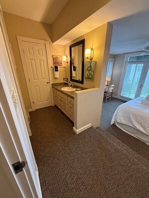 A hotel bathroom with a sink, mirror, and towel rack. - 3 Bedroom Condo with stunning sunset views located in The Homestead Resort! (Glen Arbor)