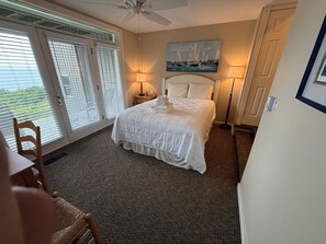 A hotel room with a bed, a desk, a chair, and a painting on the wall. - 3 Bedroom Condo with stunning sunset views located in The Homestead Resort! (Glen Arbor)