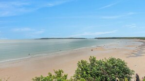 A beach with clear skies and calm waters, surrounded by greenery. - Cheriton Ground Floor includes EV Charge Parking & Dog (Tenby)