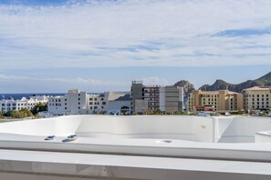 A hotel rooftop with a view of the sea and mountains. - Heart of Cabo|3BR Oasis|Rooftop Spa|Poolside (Cabo San Lucas)