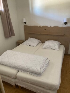 A double bed with a quilted blanket, two bedside tables, and a headboard with wall-mounted lamps. - Apartment for 6 people at the base of the slopes: L'Ecrin des neiges *** (Chamrousse)