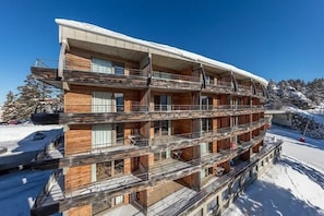 A multi-story hotel with balconies and a snowy landscape. - Apartment for 6 people at the base of the slopes: L'Ecrin des Neiges (Chamrousse)