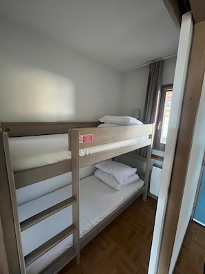 A bunk bed with a ladder, a window with curtains, and a door leading to another room. - Apartment for 6 people at the base of the slopes: L'Ecrin des Neiges (Chamrousse)