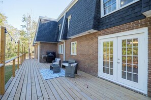 A deck with outdoor furniture, a grill, and a brick wall. - Sleeps 18 Riverfront Getaway with Game Room & Deck (Valdosta)