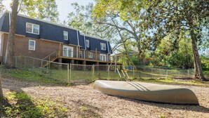 A residential area with a house, a fenced yard, and a canoe. - Sleeps 18 Riverfront Getaway with Game Room & Deck (Valdosta)