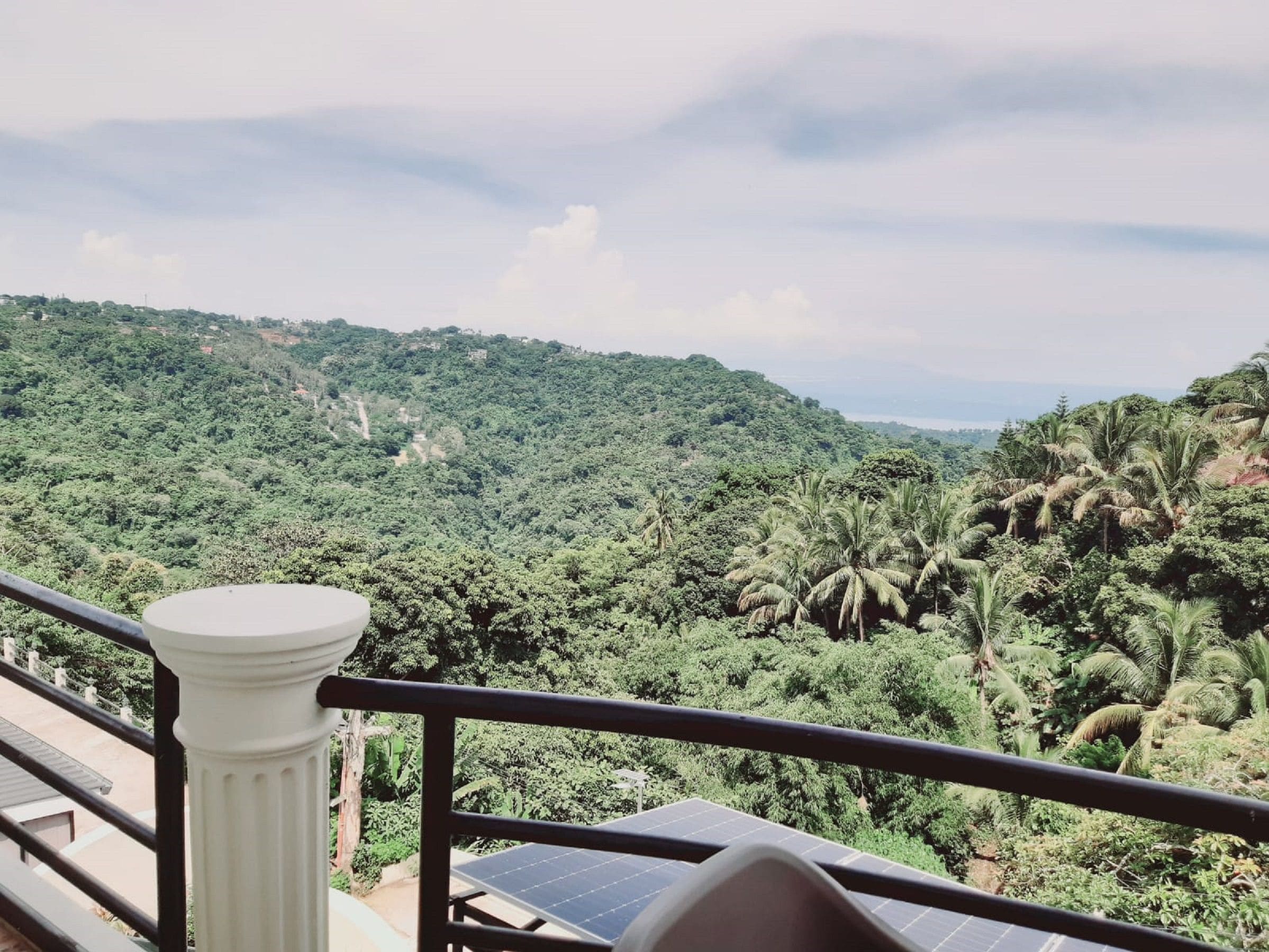 Un balcón con vistas a un paisaje verde exuberante y paneles solares.