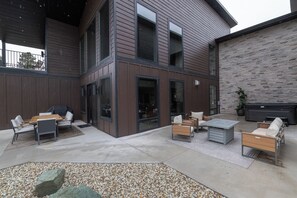 Eine Außenpatio-Terrasse mit Sitzgelegenheiten, einem Grill und einem gepflasterten Weg.