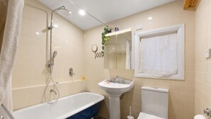 A bathroom with a bathtub, a sink, a toilet, and a shower. - Tranquil Cottage Lovely Street, Walk to Leura (Leura)