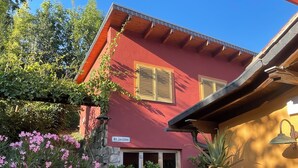 A red building with a stone wall, a wooden door, and a sign reading 'Am Jakobstein.' - Tuscan flair in the west of Dresden, not far from Nice in Saxony - Radebeul (Dresden)
