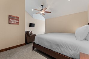 A bedroom with a bed, a ceiling fan, a wall-mounted TV, and a motivational quote on the wall. - Spacious Wildernest Retreat with Private Hot Tub (Silverthorne)