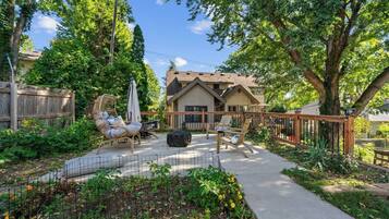 A residential backyard with a patio, outdoor furniture, and a house in the background.
